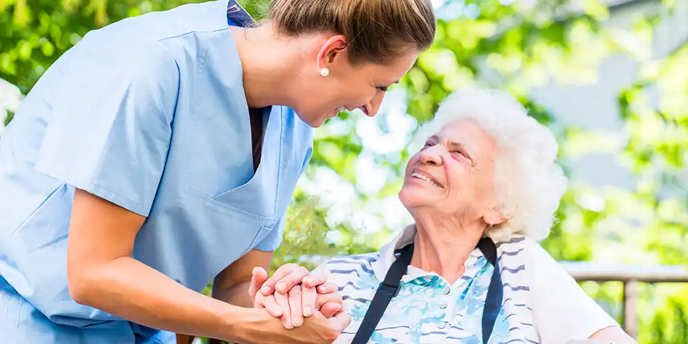 nurse with elderly patient outside